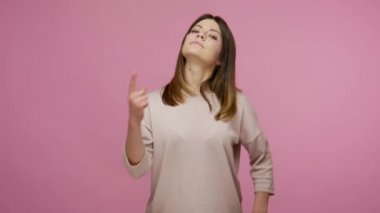 Ben buyum! Gururlu narsist güzel esmer kadın kendini gösteriyor ve kibirle bakıyor, başarılarında kendini ünlü ve bencil hissediyor. Pembe arka planda kapalı stüdyo çekimleri