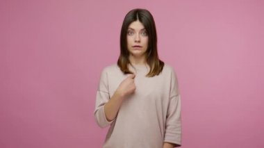 İnanılmaz, bu benim meziyetim mi? Şaşırmış bir kadın kendini işaret ediyor, şok olmuş ve ani başarısıyla seviniyor, inançsız bir tepki gösteriyor. Pembe arka planda kapalı stüdyo çekimleri