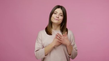 Sevgilim ol! Sevimli, esmer, genç bir kadın. Romantik duyguları kalp el hareketleriyle ifade ediyor. Sevgiyi, ilgiyi ve şefkati gösteriyor. Pembe arka planda kapalı stüdyo çekimleri