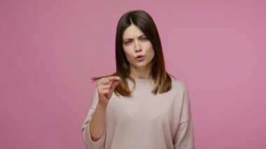 Hayal kırıklığına uğramış esmer kadın parmaklarıyla küçük bir jest yapıyor, küçük beden, düşük reyting, 2,5 cm boyunda, santimetre boyunda. Pembe arka planda kapalı stüdyo çekimleri