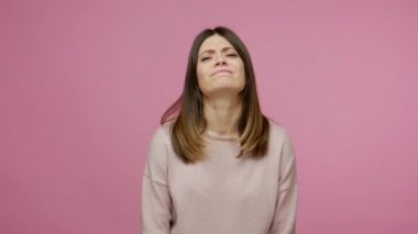 Yüz bakımı, üzüntü duyguları. Endişeli esmer kadın yüzüne tokat atıyor ve pişmanlığını dile getiriyor. Sorunlar için kendini suçluyor. Çaresiz hissediyor. Pembe arka planda kapalı stüdyo çekimleri