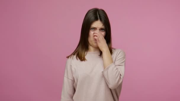 悪臭への反発 ブルネットの女の子の指で鼻をつかむ ひどいおならガス 耐えられない匂いを避けるために息を保持し 停止ジェスチャーを示す ピンクの背景に隔離されたスタジオショット — ストック動画