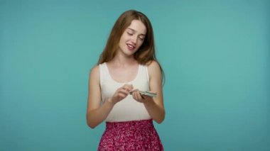 Kibirli zengin kız gururlu bir ifadeyle dolar saçıyor, zengin hayatıyla övünüyor, etrafa para saçıyor, parayı çarçur ediyor. Mavi arka planda kapalı stüdyo çekimleri