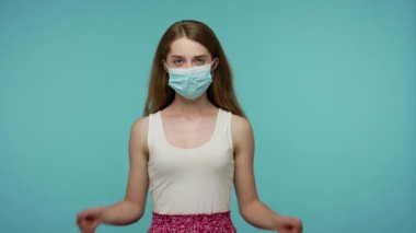 Solunum enfeksiyonunu önlemek için hijyenik tıbbi maske takan ve baş parmak gösteren bir kız. Grip, bulaşıcı koronavirüs gibi hava salgını hastalıklarına karşı mükemmel bir koruma. Stüdyo çekimi izole