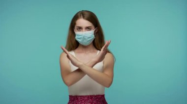 Solunum enfeksiyonunu önlemek için hijyenik yüz maskesi takan ve x işareti gösteren bir kız, hava salgını, grip, bulaşıcı koronavirüs uyarısı olarak jesti yapmayı kes. Stüdyo çekimi izole