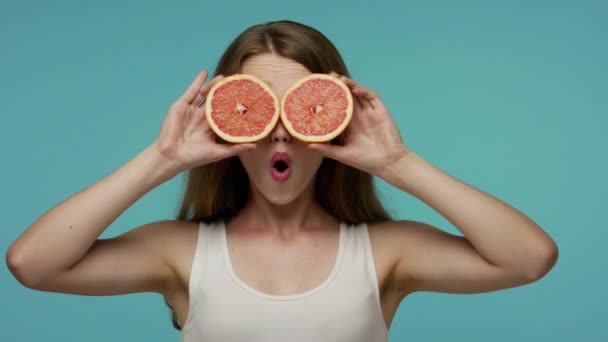 Menina Otimista Feliz Cobrindo Olhos Com Toranjas Mostrando Língua Para — Vídeo de Stock