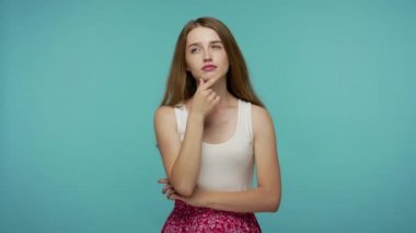 Mutlu, ilham verici bir kız, meditasyonlu, pozitif bir ifadeyle düşünüyor, harika bir fikir çözümü ile parmağını kaldırıyor, cevabı biliyor, dahiyane bir plan, yaratıcı düşünce. Stüdyo çekimi mavi arkaplanda izole edildi