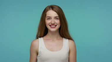 Sevimli, sevimli, mutlu bir kız kameraya uzanmış el sıkışma, nazik bir gülümsemeyle karşılama dayanışma ve güven konsepti sunuyor. Mavi arka planda kapalı stüdyo çekimleri