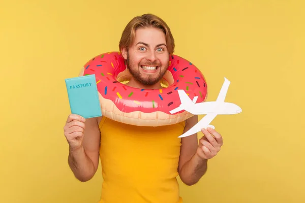 Pembe Donut Kauçuk Yüzüğüyle Ayakta Duran Elinde Pasaport Uçak Maketi — Stok fotoğraf