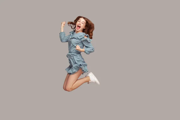 Delighted Enthusiastic Girl Ruffle Dress Flying Mid Air Raised Fists — Stock Photo, Image