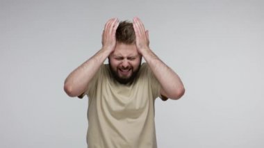 Grip hastası sakallı adam şakaklarını ovuyor ağrıyı dindirmek için başını sıkıyor, baş ağrısı, şiddetli migren, stres gerilimi, ateş ve grip belirtileri hissediyor. Stüdyoda çekim izole edildi