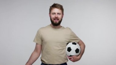 Futbol tişörtlü, elinde futbol topu tutan ve Avrupa Birliği bayrağı sallayan neşeli, mutlu futbol fanatiği, favori spor maçı için tezahürat yapan adam. Stüdyo çekimi izole, gri arkaplan