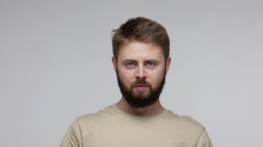 Yakın plan sakallı adam yapbozun parçalarını birleştiriyor, yapbozun iki parçasını birleştiriyor, çözümü bulmak için konsept, tam eşleşme unsurları, bağlantı ve birlik. Stüdyo çekimi gri arkaplanda izole edildi