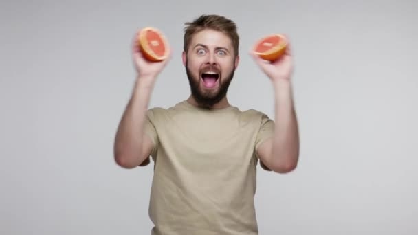 Homem Dividindo Toranja Duas Metades Cobrindo Olhos Com Fatias Divertindo — Vídeo de Stock