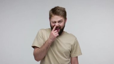 Komik, kültürsüz, kirli burun karıştıran, sümük çıkaran, kameraya iğrenç sümükler atan, kötü davranışlar, çirkin davranış bozukluğu konsepti. Gri arka planda kapalı stüdyo çekimi