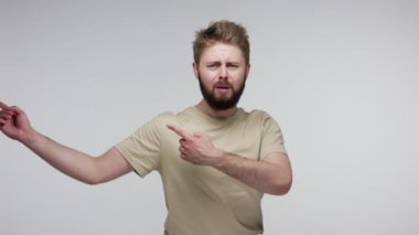 Çık dışarı! Sakallı adam kavga ederken, azarlarken ve ayrılırken, çıkışı gösterirken, onu yalnız bırakmak isterken, kızgın kameraya bakarken. Gri arka planda kapalı stüdyo çekimi