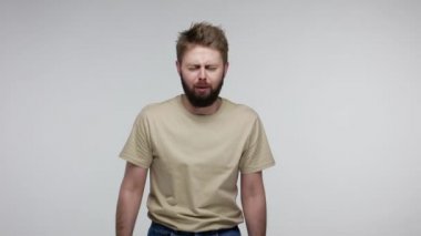 Soğuk algınlığı, mevsimsel grip. Sakallı bir adamın öksürmesi, ağızını eliyle kapatması, boğma alerjisi veya grip belirtileri, çovid zatürree riski, akciğerlerde sorun. Gri arka planda kapalı stüdyo çekimi