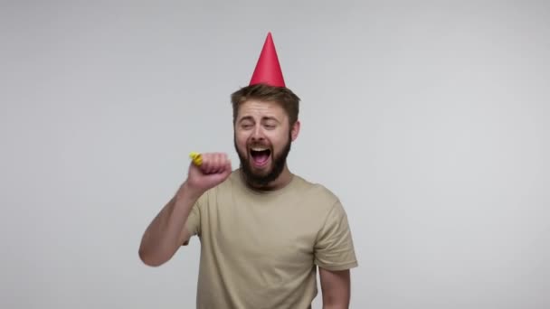 Optimistic Delighted Bearded Guy Funny Cone Hat Laughing Blowing Party — Stock Video