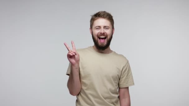 Vrolijke Optimistische Bebaarde Man Shirt Met Een Overwinningsteken Hopend Succes — Stockvideo