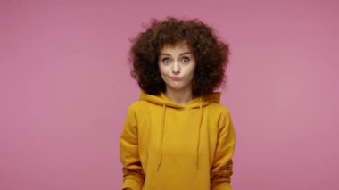 Ne diyeceğimi bile bilmiyorum! Kafası karışık afro saçlı saçları olan, omuz silken belirsiz bir soru sormaktan utanan, kuşkuları olan bir kız. Pembe arka planda kapalı stüdyo çekimleri