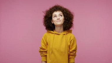 Kapüşonlu güzel afro saçlı kadın mutlu meditasyon ifadesiyle hayal kuruyor hoş anıların, kız gibi umutların ve dileklerin keyfini çıkartıyor. Stüdyo çekimi pembe arkaplanda izole edildi