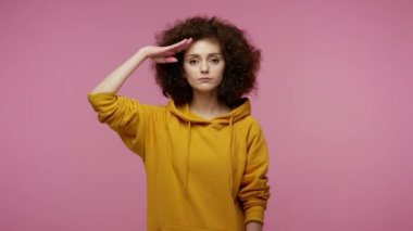 Evet, efendim! Çok sorumlu, vatansever, kukuletalı, kapüşonlu bir kız. Saygı ile selamlıyor, komutandan emir bekliyor, itaat ediyor ve disiplini uyguluyor. Pembe arka planda kapalı stüdyo çekimleri