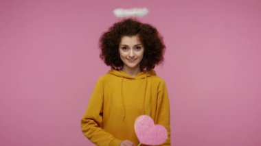 Sevgililer Günün kutlu olsun! Melek gibi saçları olan, pembe bir kalp taşıyan, neşeli görünen, hava öpücüğü veren, sevgi gösteren, romantik duygular besleyen bir kız. Stüdyo çekimi izole