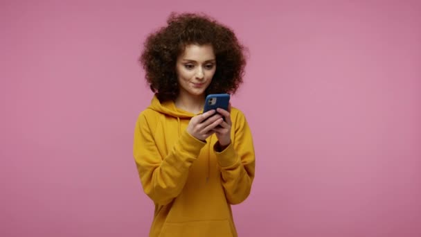 Kapüşonlu Kapüşonlu Saçlarıyla Şık Mutlu Bir Kız Cep Telefonuyla Mesaj — Stok video