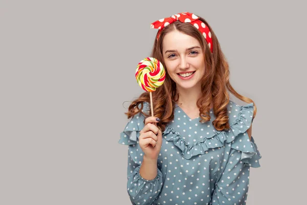 Ładna Bluzka Falbankami Trzymająca Słodkie Spiralne Cukierki Patrzące Obiektyw Uśmiechające — Zdjęcie stockowe