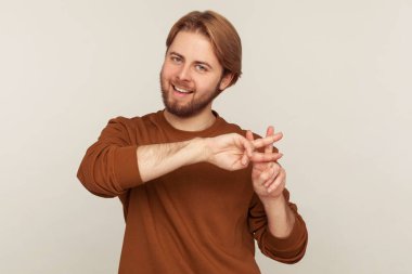 Viral internet konusu. Sweatshirt 'lü neşeli sakallı adamın portresi neşeyle gülümseyen ve hashtag jesti gösteren sosyal medyada mesajın esrar sembolü. Stüdyo çekimi gri arkaplanda izole edildi