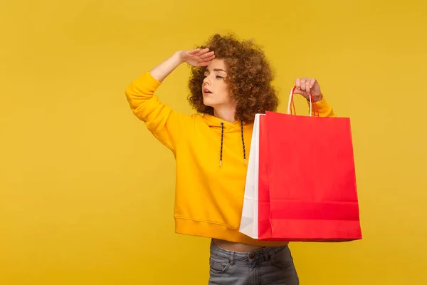 Retrato Menina Hipster Cabelos Encaracolados Curiosos Capuz Segurando Sacos Compras — Fotografia de Stock