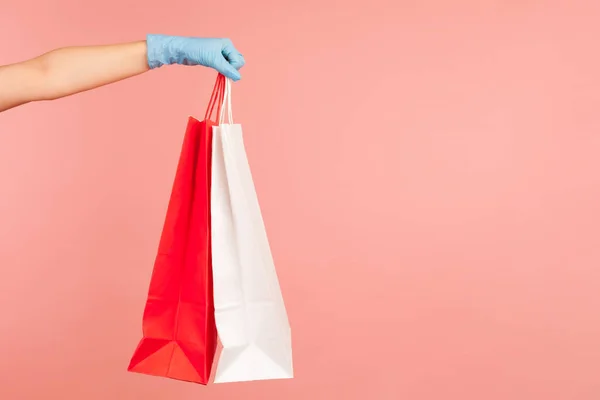 Kırmızı Beyaz Alışveriş Torbası Tutan Mavi Eldivenli Insan Elinin Profil — Stok fotoğraf
