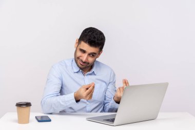 Kurnaz işadamı ofis işyerinde oturuyor, kurnaz bir ifade takınıyor ve bilgisayar ekranına para hareketi yapıyor, video görüşmesinde kârdan bahsediyor. Beyaz arka planda izole edilmiş kapalı stüdyo çekimi