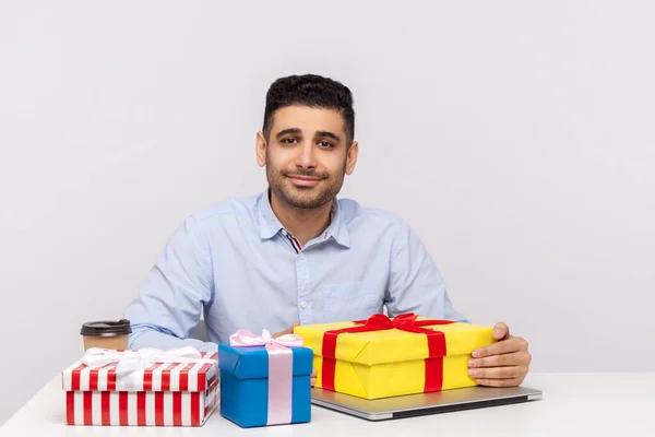 Glücklicher Mann Büroangestellter Arbeitsplatz Umgeben Von Geschenkboxen Und Freundlich Lächelnd — Stockfoto