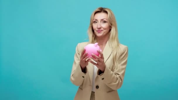 Szczęśliwa Uśmiechnięta Blondynka Biznesowej Kurtce Trzymająca Skarbonkę Rękach Pokazująca Kciuki — Wideo stockowe