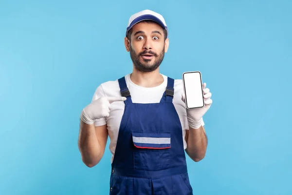 Handyman Sorprendido Overoles Guantes Apuntando Teléfono Móvil Con Pantalla Simulada —  Fotos de Stock