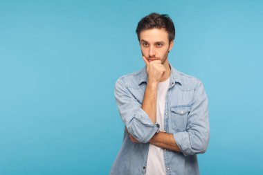 Derin düşünceler içinde. İşçi kot gömleği giymiş zeki yakışıklı bir adamın portresi. Fikir üzerinde kafa yoruyor, plan üzerinde kafa yoruyor, zor seçimler hakkında şüpheleri var. Stüdyoda çekim izole edildi