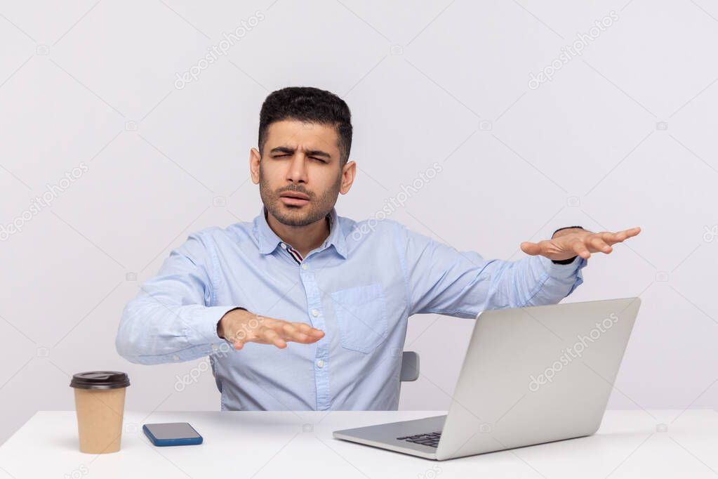 Blind disoriented man employee sitting office workplace, outstretching hands trying to find laptop on desk, vision loss concept, eyesight problems. indoor studio shot isolated on white background