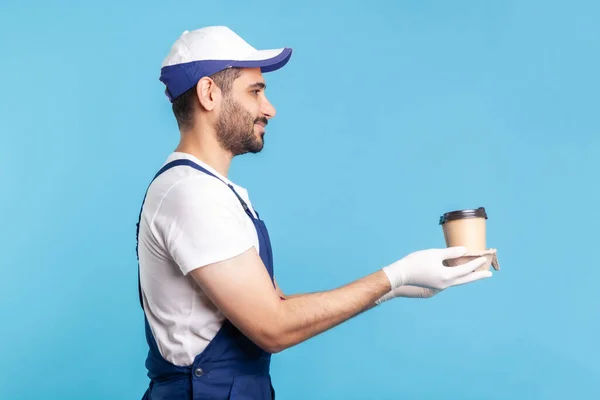 Bezorgservice Zijaanzicht Vriendelijke Vrolijke Koerier Overalls Die Koffie Aanbieden Veiligheidshandschoenen — Stockfoto