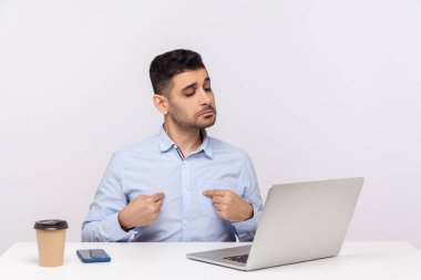 Ben buyum! Bencil işadamı ofis işyerinde oturuyor, kendini gösteriyor ve kendine güvenen kibirli bir şekilde dizüstü bilgisayar ekranına bakıyor, video görüşmeleri yapıyor ve böbürleniyor. Stüdyoda çekim izole edildi