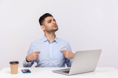 Ben buyum! Ofis işyerinde dizüstü bilgisayarıyla oturan kibirli bencil işadamı kendini gösteriyor ve kendinden emin görünüyor, başarısından gurur duyuyor. Stüdyo çekimi beyaz arkaplanda izole edildi