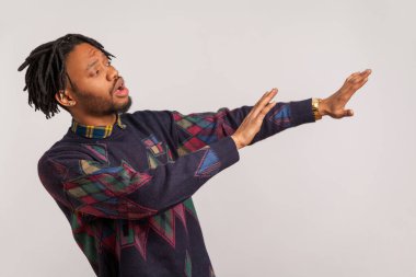 Sakın bana gelme! Korkmuş Afrikalı bir adamın portresi. Kollarını düzeltiyor. Mesafeyi korumak istiyor. Gri arka planda izole edilmiş kapalı stüdyo görüntüleri