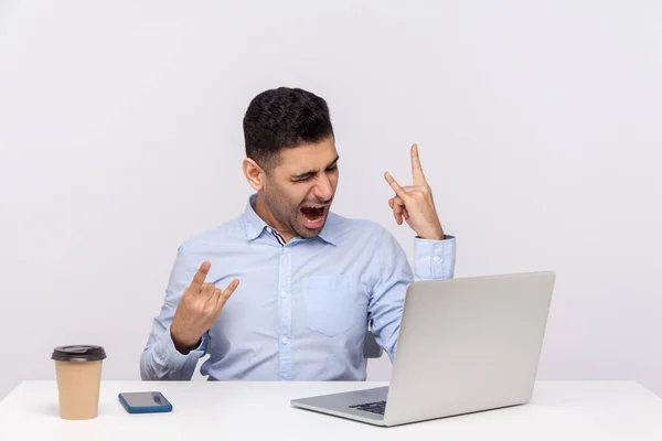 Zorgeloos Vrolijke Zakenman Zittend Kantoor Werkplek Tonen Rock Roll Hand — Stockfoto