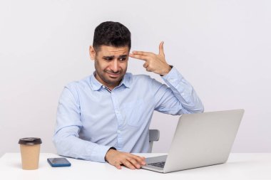 Depresyonda olan erkek çalışanlar dizüstü bilgisayarda çalışıyor, parmaklarıyla silah doğrultuyor, stresli bir işten dolayı intihar ediyor, aşırı çalışmaktan yoruluyor. Beyaz arka planda izole edilmiş kapalı stüdyo çekimi