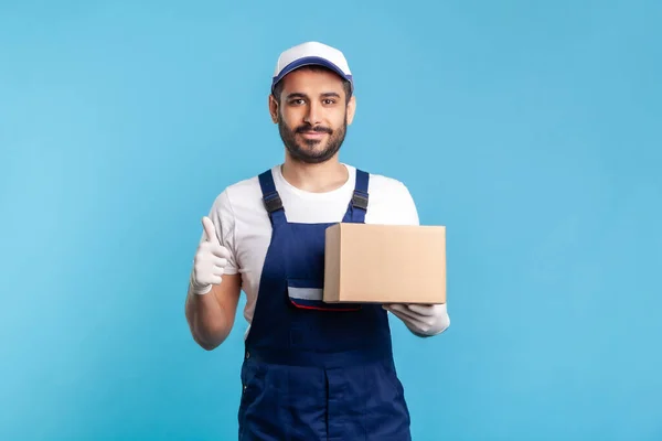 Cargo transportation, good delivery service. Satisfied courier in uniform holding cardboard box and showing thumbs up. Courier carrying parcel. Online express shipping, relocation service. isolated