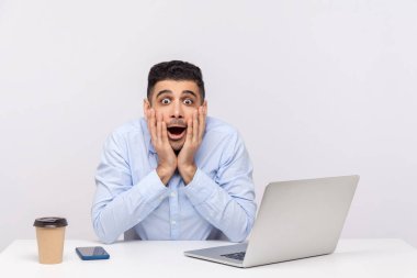 - İnanamıyorum ya! Şaşırmış işadamı, masa başında dizüstü bilgisayarı ile ofis işyerinde oturuyor, kameraya şaşkın bir ifadeyle bakıyor, ani çılgın haberlerle şoke oluyor. Stüdyo çekimi beyaz arkaplanda izole edildi