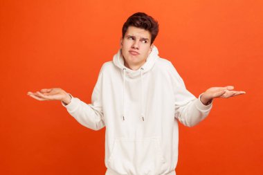 - Bilmiyorum. Havalı saçlı, omuz silken, bilinmeyen bilgilere sahip, durumla karışmış, dikkatsiz genç bir adam. Turuncu arka planda kapalı stüdyo çekimleri