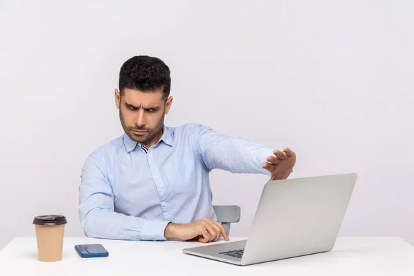 Don\'t want to look! Confused businessman sitting office workplace, showing stop to laptop screen, rejecting communication on video call, ignoring shameful gross web content. studio shot isolated