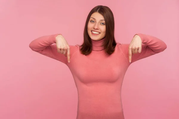스웨터 쾌활하고 긍정적 여성이 손가락을 아래로 향하여 당신의 광고를 공간을 — 스톡 사진
