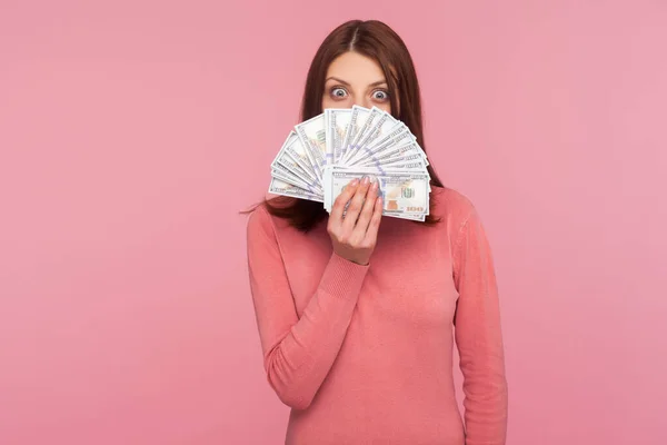분홍색 스웨터를 여성이 달러화 지폐의 얼굴을 숨기고 모습이다 스튜디오 배경에서 — 스톡 사진